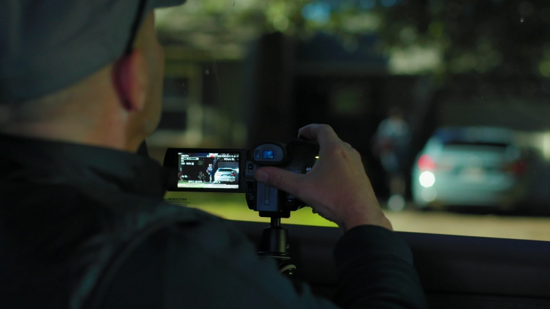 A Person Using a Camera to Gather Evidence of A Cheating Spouse from A Car